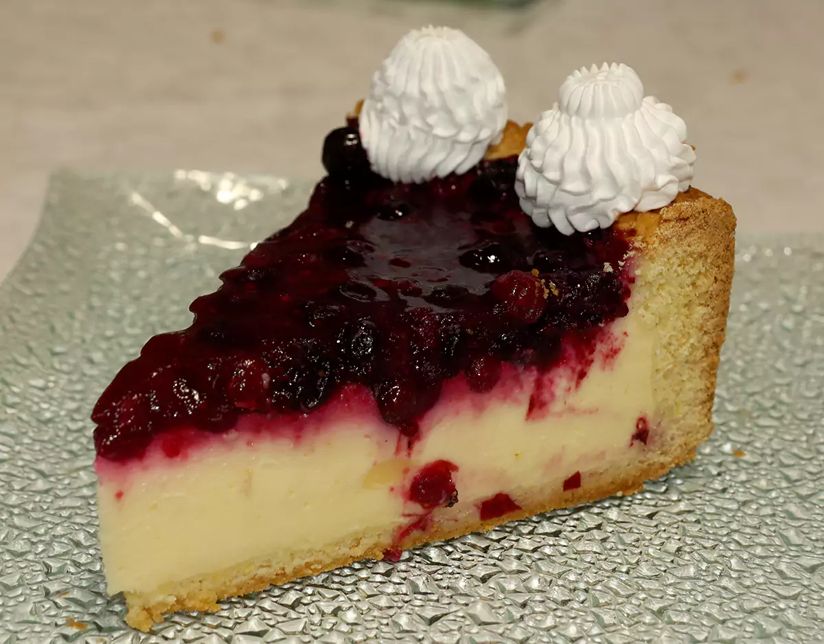 Parće kremaste Mirelam torte sa glazurom od šumskog voća i dekoracijom od šlaga.